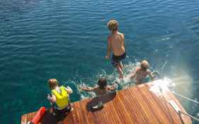 Von der Badeplattform am Boot direkt ins Wasser hüpfen